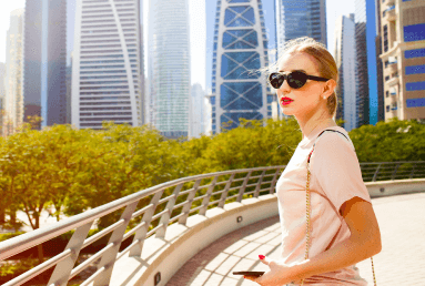 wind-blows-woman-s-hair-while-she-stands-bridge-before-beautiful-skyscrapers-dubai-1